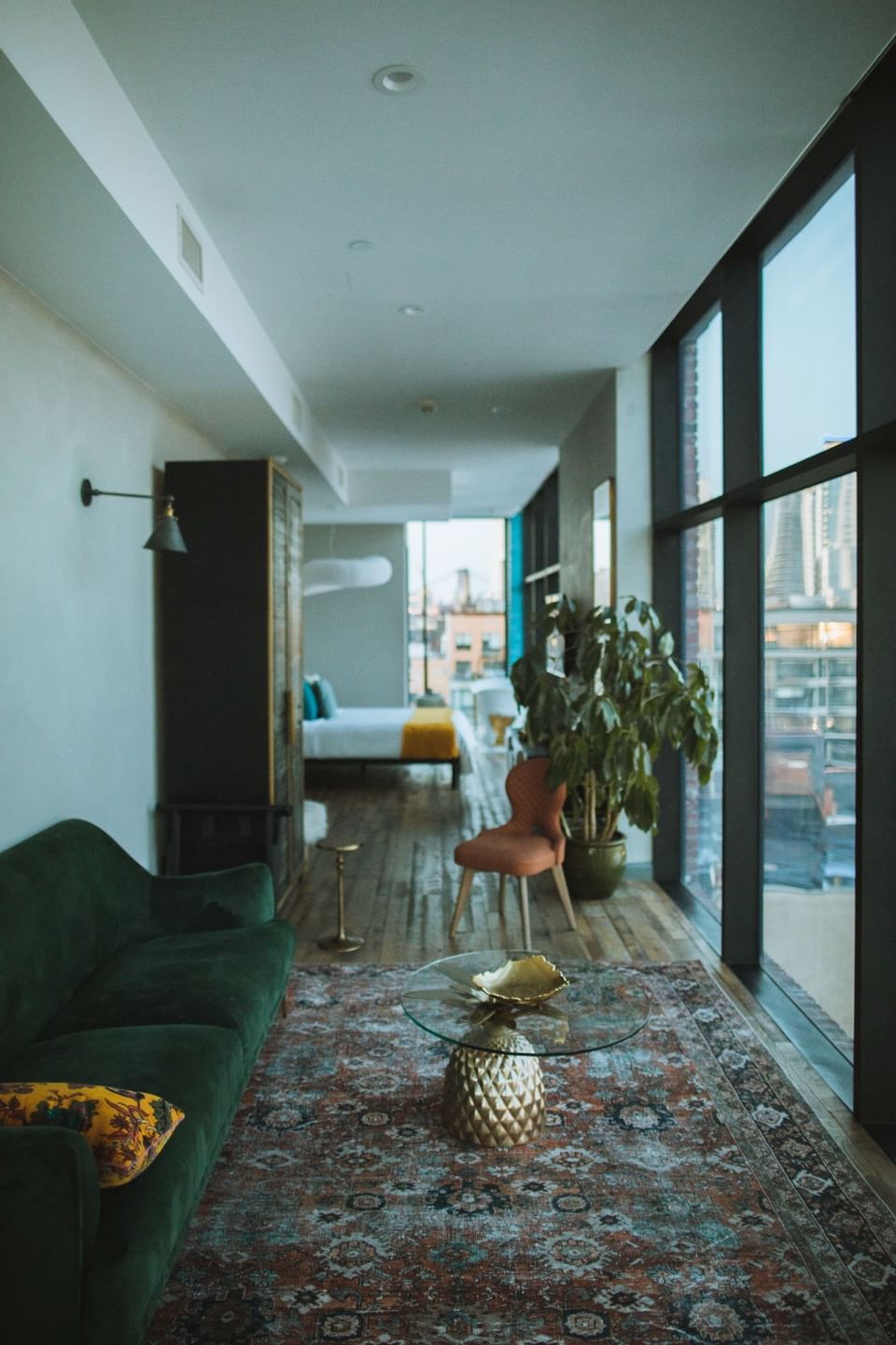 A green sofa with a glass table lying in the corridor area
