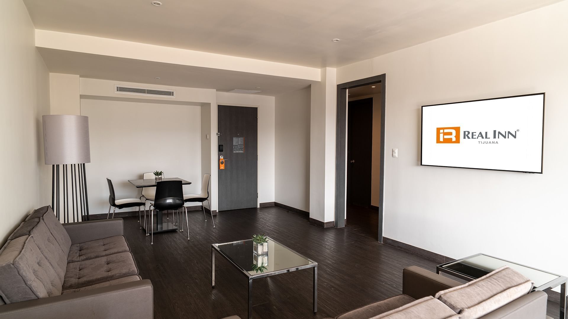 Dining table by the TV lounge area in the King Master Suite with wooden floors at Real Inn Tijuana