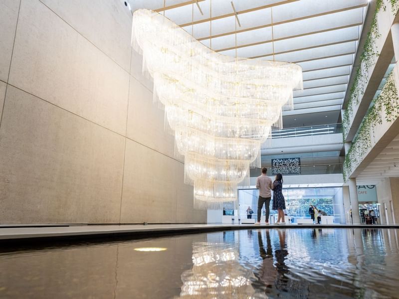 Interior of QAGOMA with a large cascading chandelier near Sofitel Brisbane Central