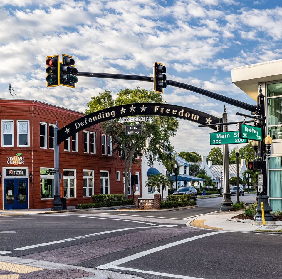 Street view of a historic red-brick visitor center with a Defending Freedom arch near The J Hotel