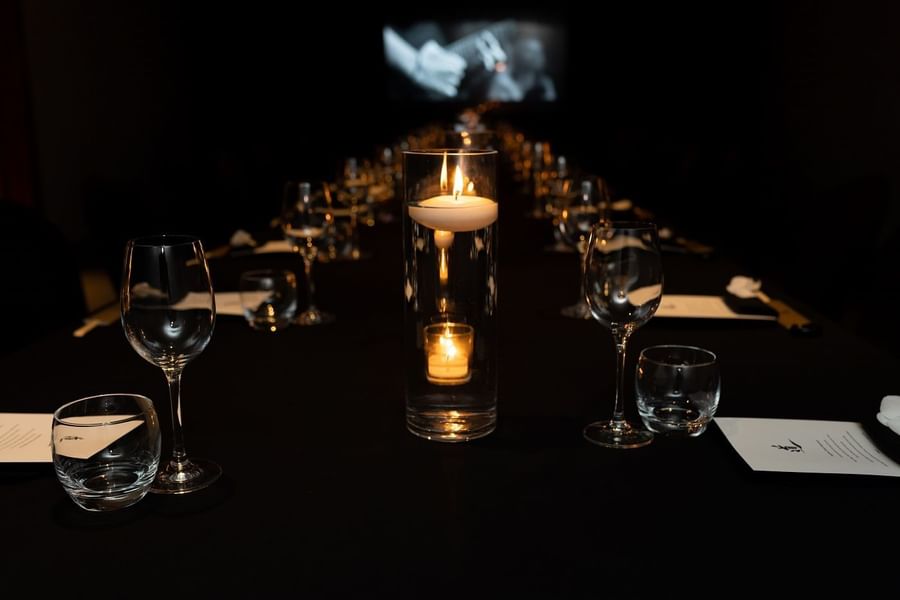 Close-up on dining table arrangement with candles in May Fair Kitchen at The May Fair Hotel