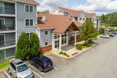 Aerial view of White River Inn and Suites, one of the top White River Junction hotels, surrounded by greenery & a parking lot