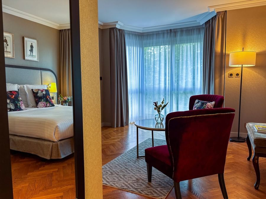 Seating area and nightstands by the bed in the Deluxe Room with wooden floors at Warwick Reine Astrid - Lyon