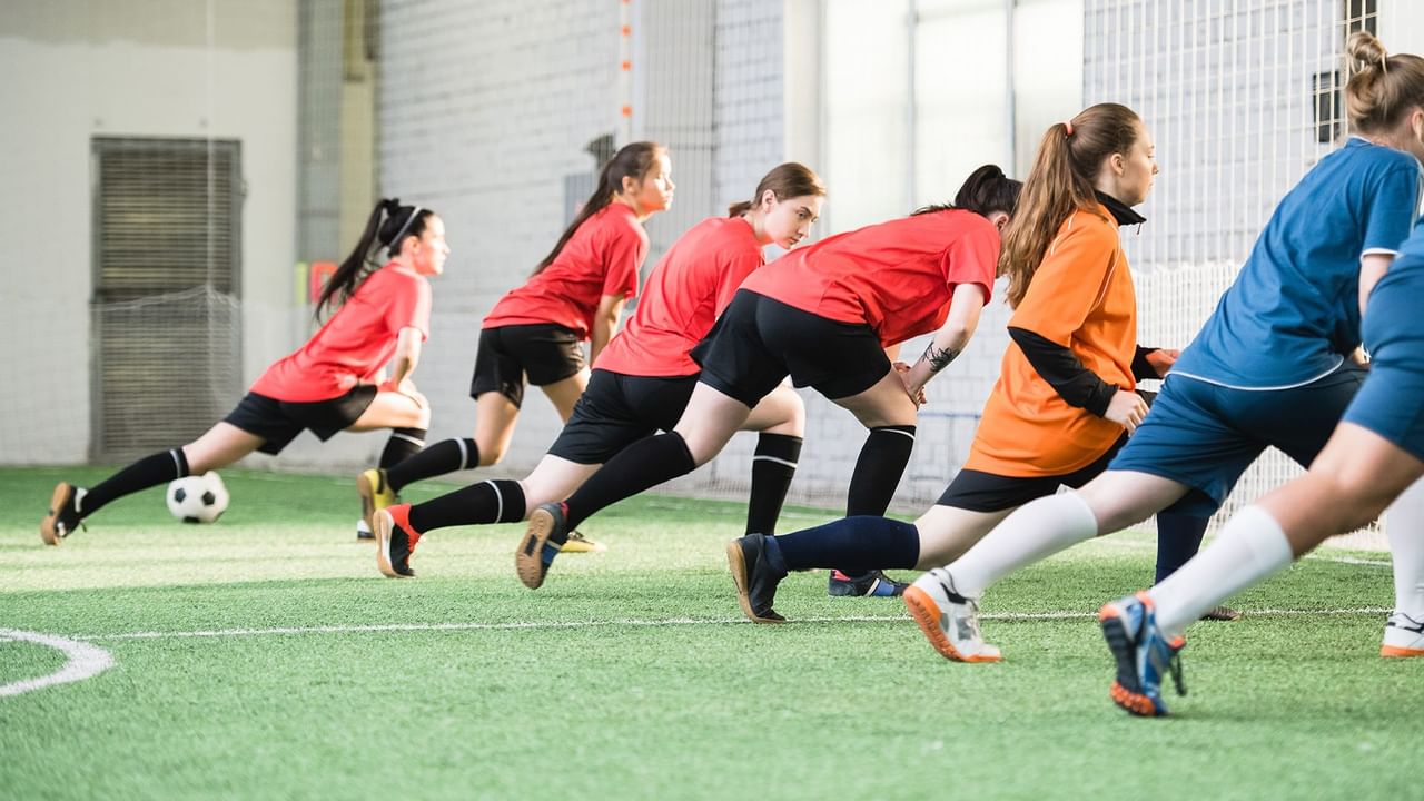 girls on an indoor football field
