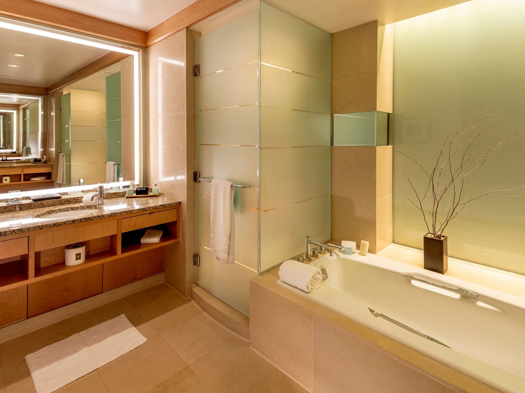 Luxury bathroom bathtub by the vanity with an illuminated mirror in Presidential Suite at The Umstead Hotel and Spa