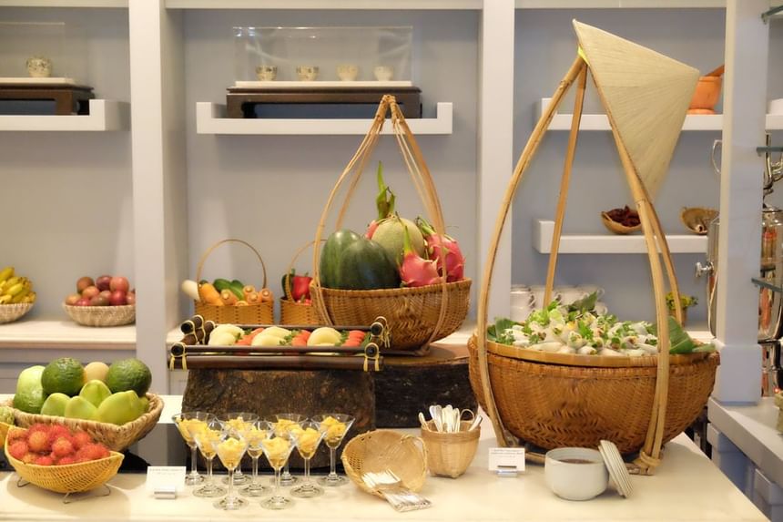 Vibrant display of fresh fruits and vegetables in woven baskets, alongside various traditional items at Park Hyatt Saigon