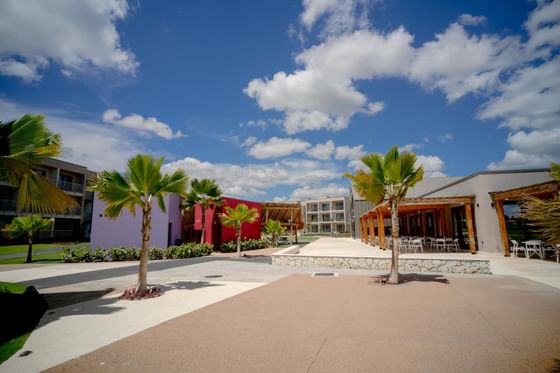 Sunny courtyard with colorful buildings and palm trees at The Hub Hotels, one of the best hotels in Dominican Republic