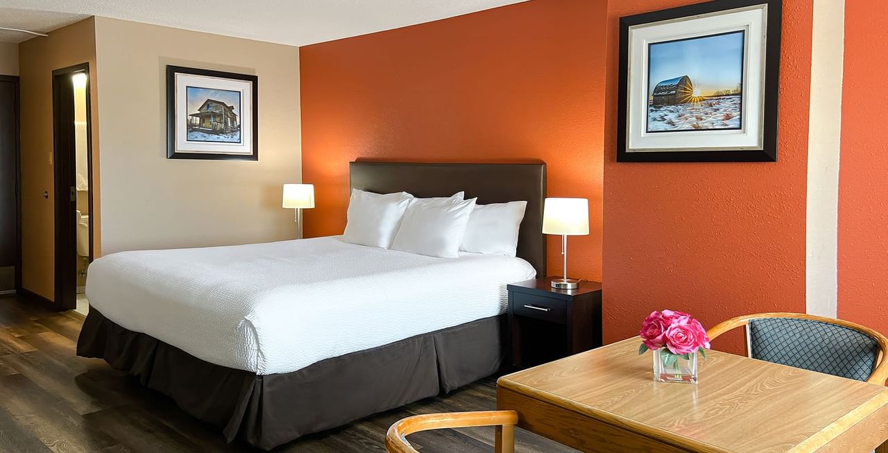 Hotel bedroom with bed, chairs, and table