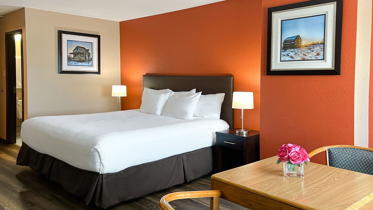 Bed, table, chairs, flowers, painting in a hotel room