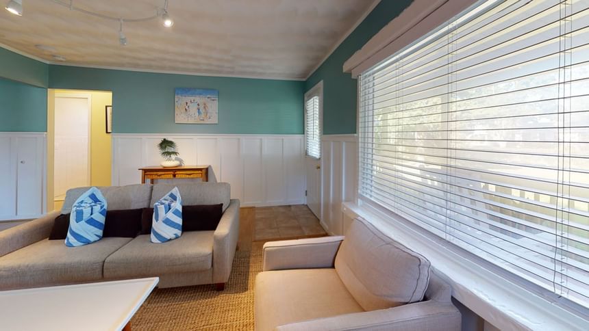 Lounge area with plush sofa by the window in Nick Cottage at Breezeway Boutique Hotel
