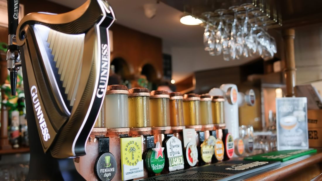 A selection of beer taps including Fenians Irish Pub and Guinness at the bar in Novotel Perth Langley's pub