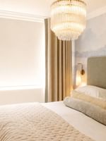One Bedroom Apartment with upholstered headboard, crystal chandelier, and neutral tones at The Capital Hotel, Apartments & Townhouse - London