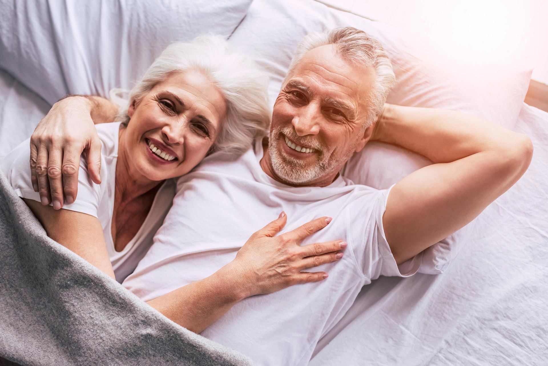 Senior couple enjoying a hotel stay in bed