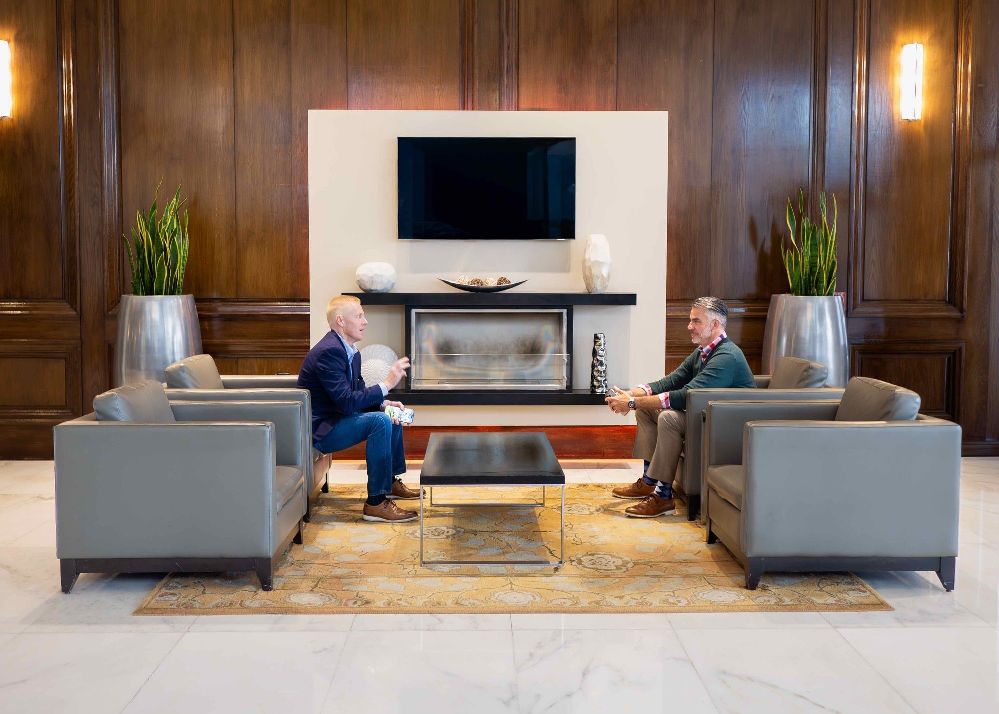 A lobby with a fireplace, seating area, and TV