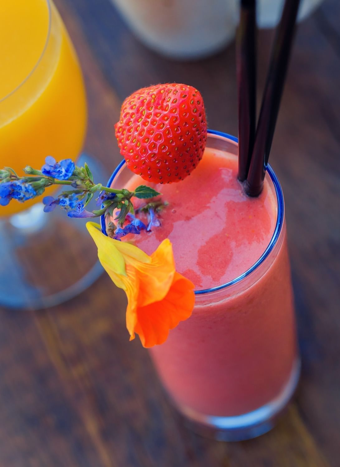 Lorem ipsum Fruit smoothie garnished with flowers and a strawberry