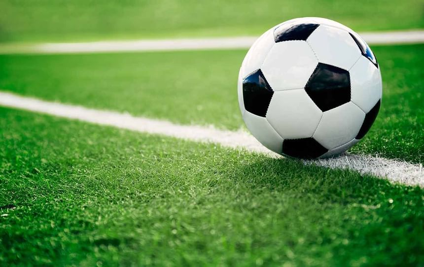 Black and white soccer ball resting on a white sideline on green grass in Miami Lakes Athletic Club at Miami Lakes Hotel