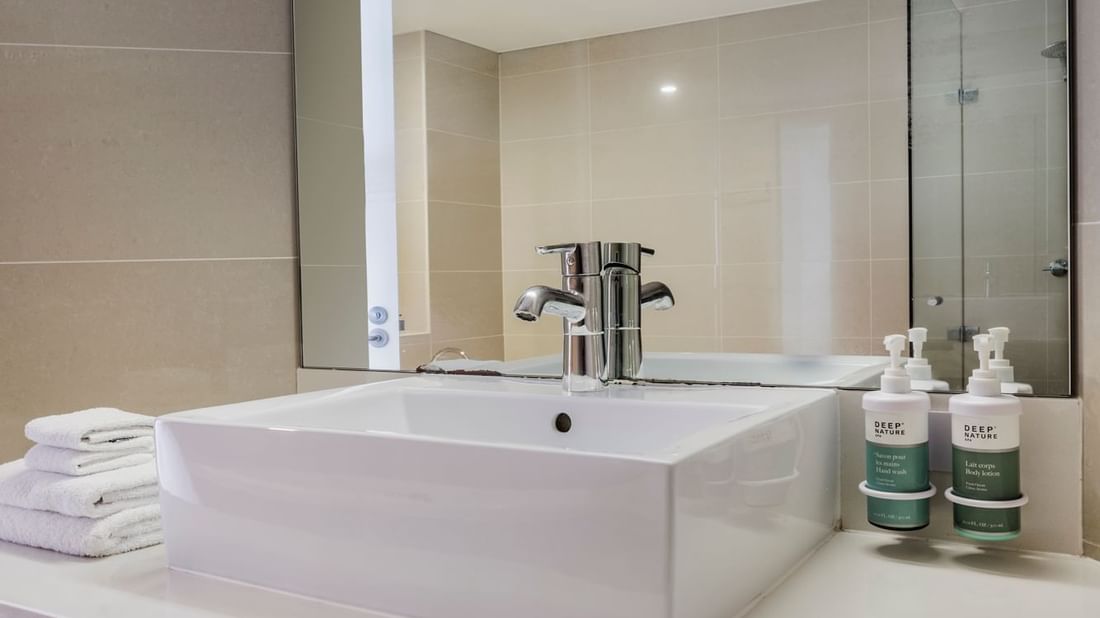 Bathroom vanity with mirror and amenities in Superior Spa Suite at Novotel Sydney Olympic Park