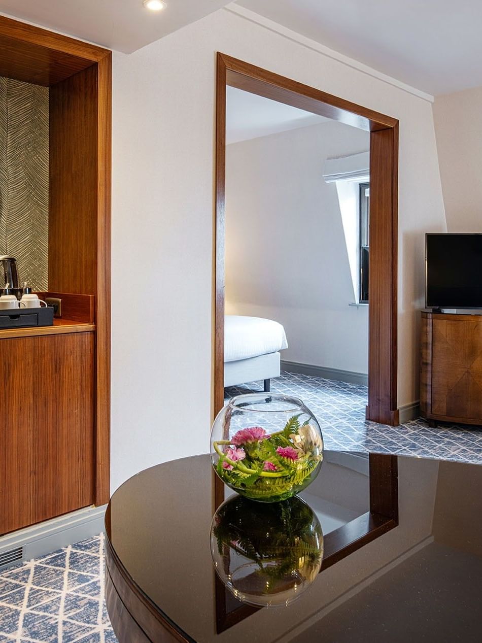 Coffee station with a mirror placed by a bowl of flowers in Junior Suite at Warwick Grand Place Brussels