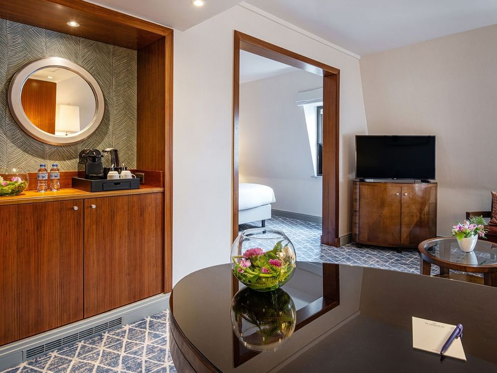 Coffee station with a mirror placed by a bowl of flowers in Junior Suite at Warwick Grand Place Brussels