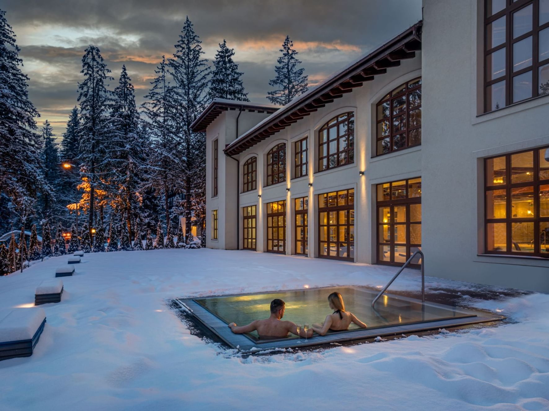 Couple in outdoor hot tub in winter at Ana Hotels Bradul Poiana Braşov