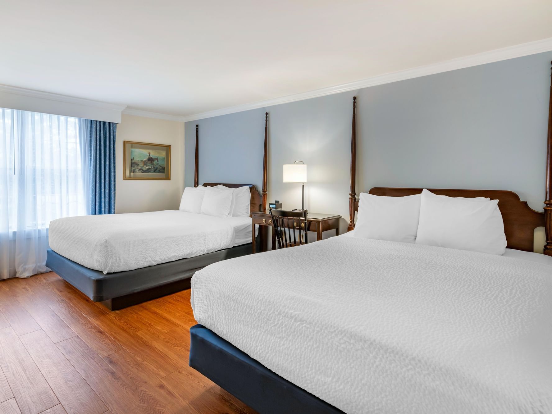 Mid-century furniture with wooden floors in the 2 Queen Pet-Friendly room at Harraseeket Inn