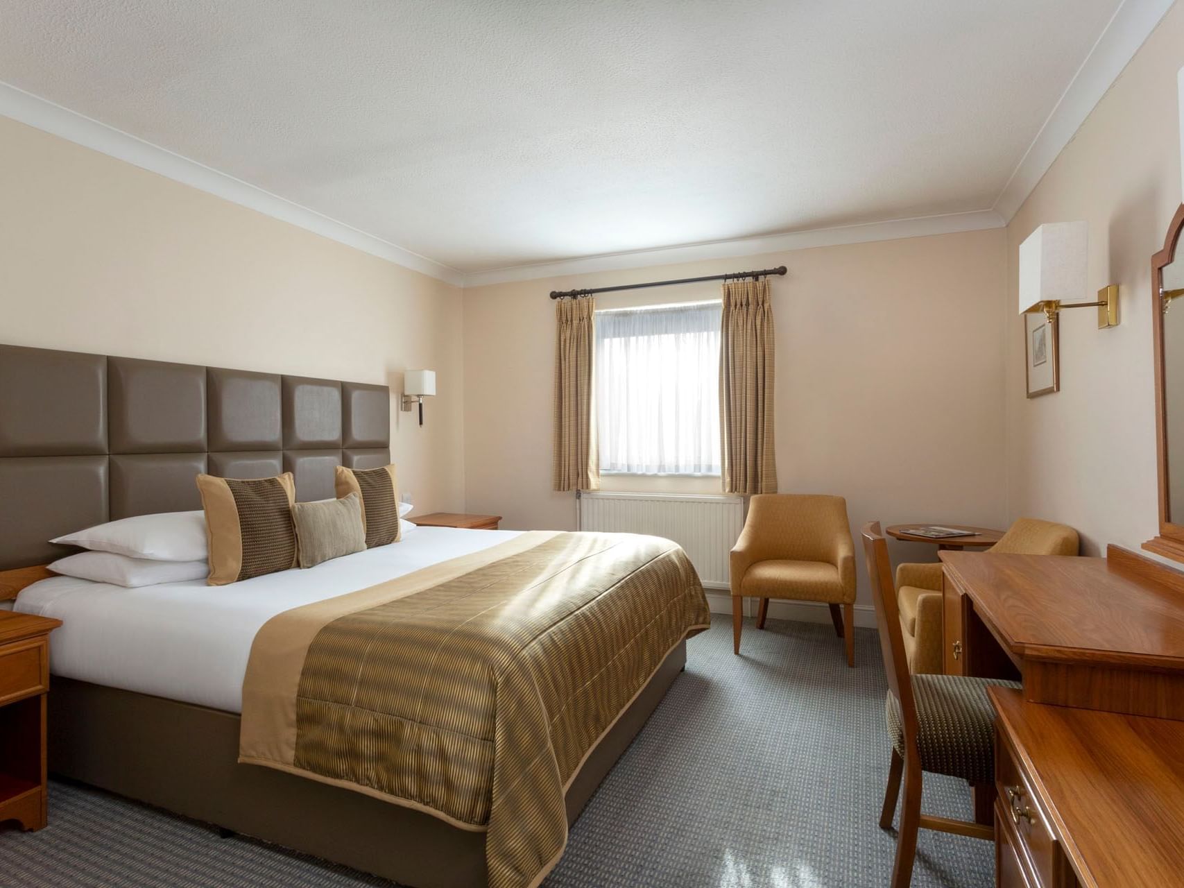 A bed with work desk in Standard Room at Bridgewood Manor Hotel