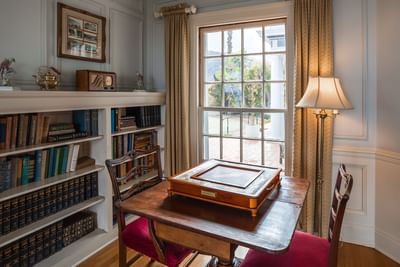 Room with wooden desk, bookshelves and a Monopoly board game at Mt Ada