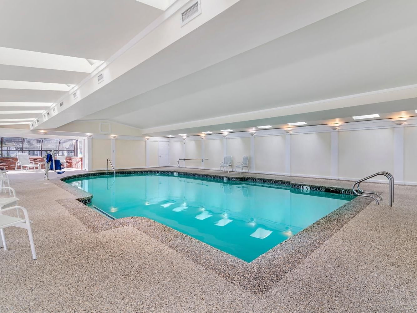 Indoor pool & relaxation area at Meadowmere Resort with lounge chairs