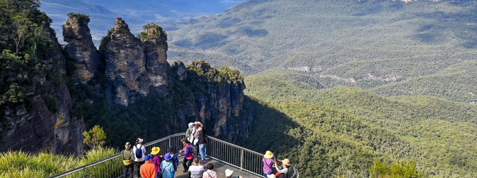 Tourists on a lookout point admiring the scenic view of the valley at Echo Point Walks and Talk.