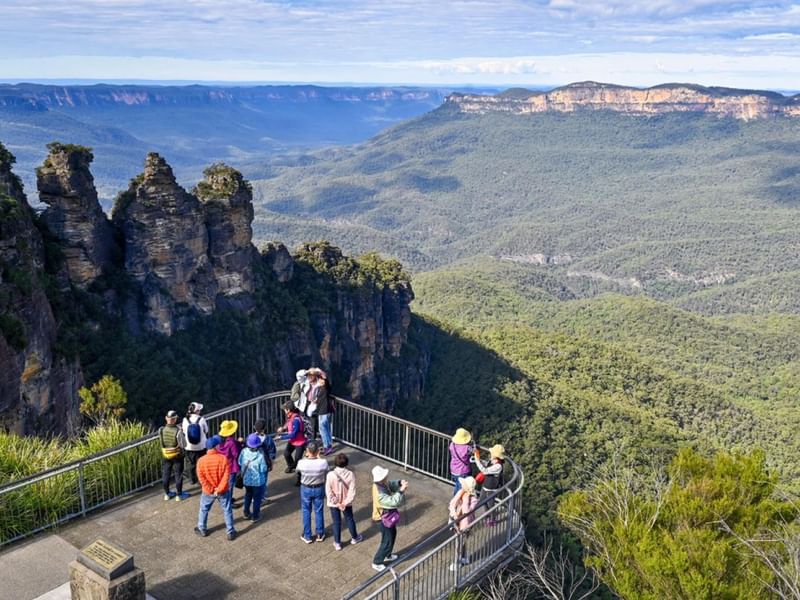 Tourists on a lookout point admiring the scenic view of the valley at Echo Point Walks and Talk.