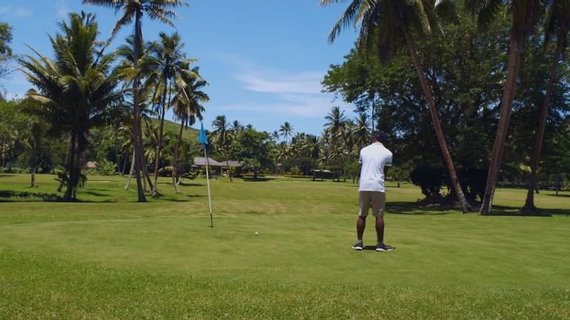 A man playing golf in a golf court at The Naviti Resort