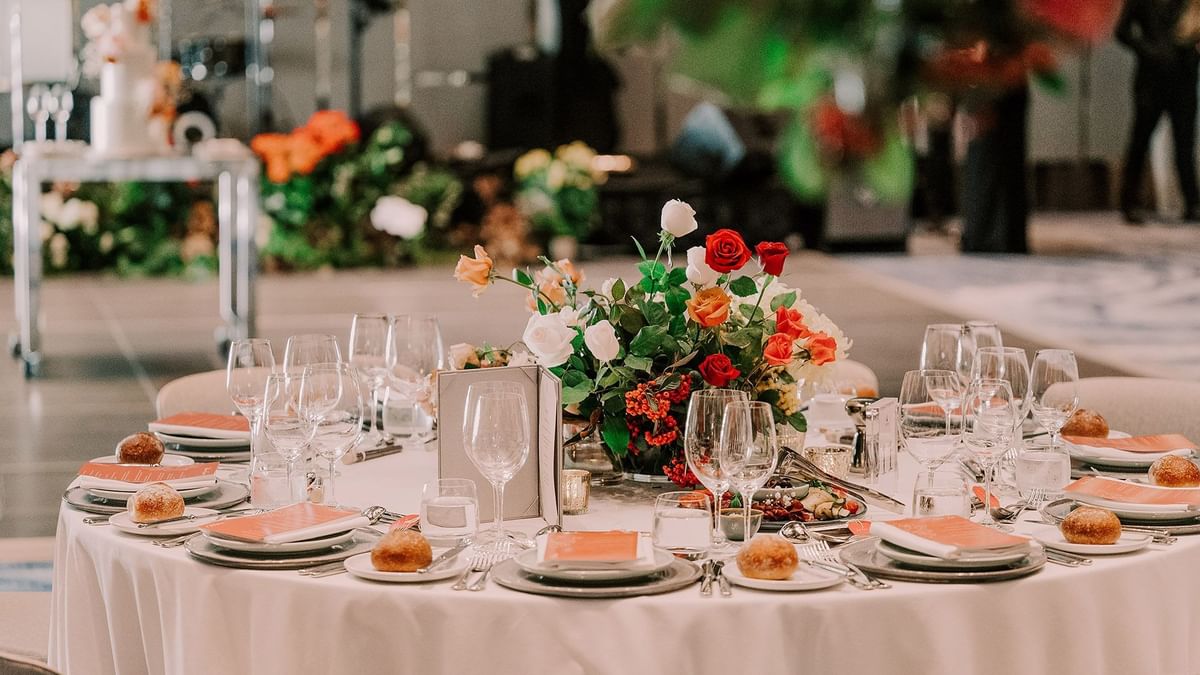 Elegantly set dining table with floral centerpiece in a wedding hall at Crown Towers Sydney