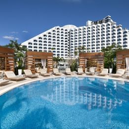 Close-up on the outdoor pool with sun beds at Crown Metropol