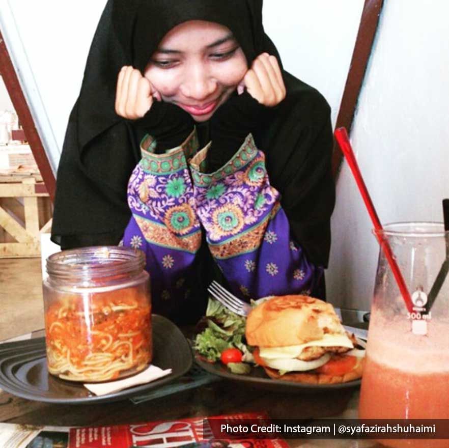 A woman was taking pictures with the delicious dishes at Caffeine Chemistry Coffee Cafe - Lexis Suites Penang