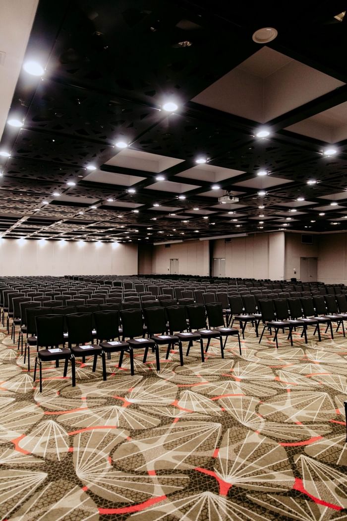 Empty conference room with carpeted floor and rows of chairs at Novotel Sydney Parramatta