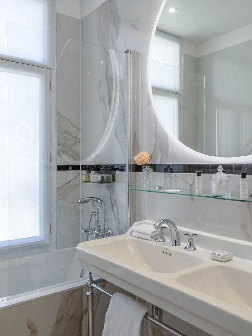 Elegant bathroom with dual sinks and Rue de la Paix View at Hôtel Westminster - Paris.