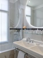 Elegant bathroom with dual sinks and Rue de la Paix View at Hôtel Westminster - Paris.