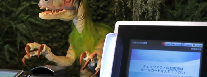 Unique robotic dinosaur receptionist at the front desk check-in kiosk with a digital screen at Henn Na Hotel New York