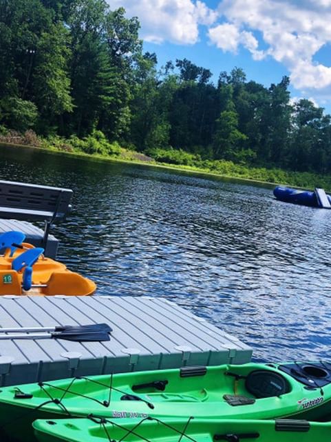 Kayaks and a pedal boat docked by the jetty near Cove Pocono Resorts