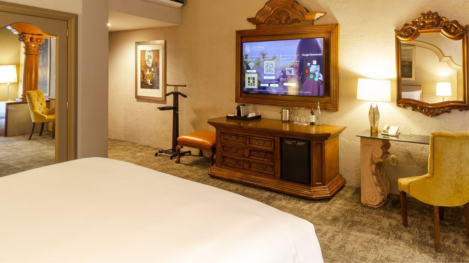 King Grand Class showing a smart TV setup, valet stand, and plush carpeting at Quinta Real Guadalajara