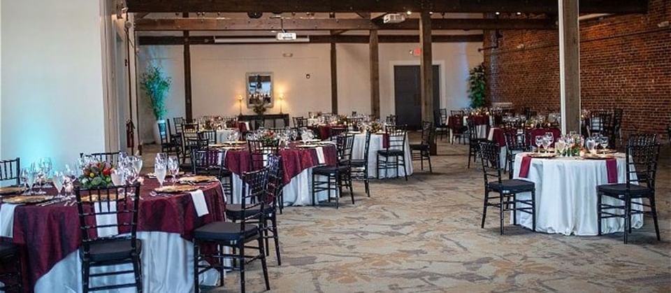 Banquet tables arranged in an event hall with a rustic atmosphere in Inn at the Crossroads