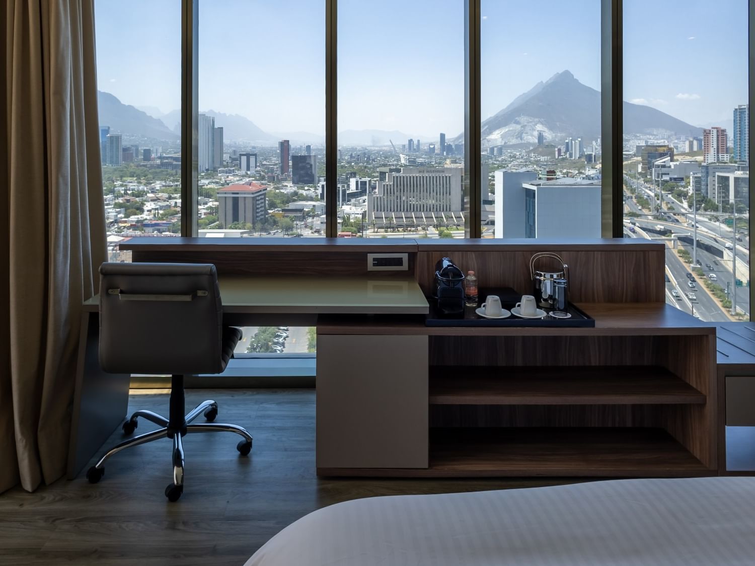 Junior Suite King con escritorio, ventanales amplios y vistas panorámicas de Monterrey en Camino Real Fashion Drive