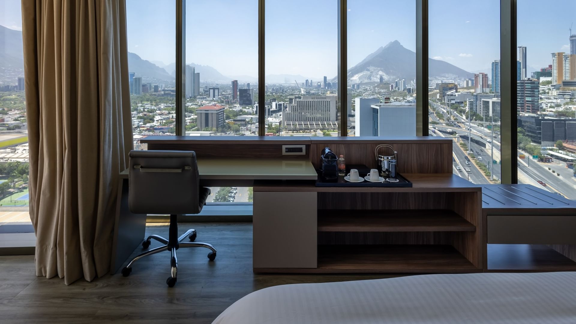 Junior Suite King con escritorio, ventanales amplios y vistas panorámicas de Monterrey en Camino Real Fashion Drive