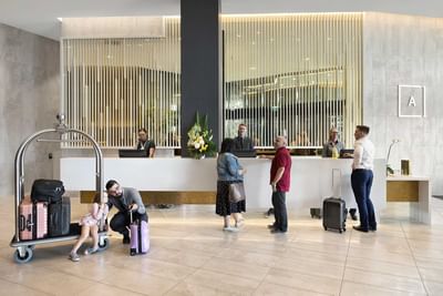 People at the check-in with luggage at Alcyone Hotel Residences a hotel close to Brisbane airport