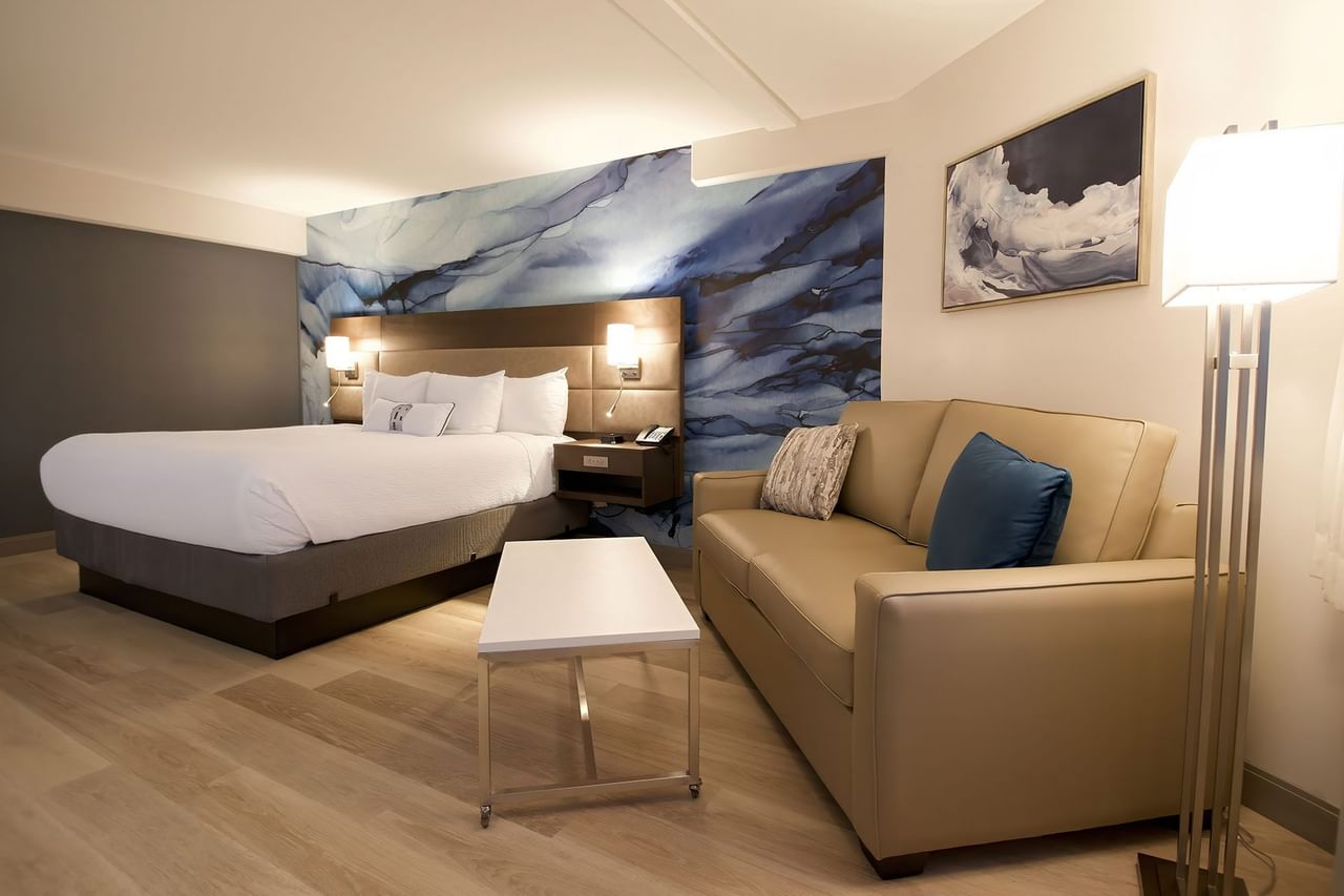 Hotel guestroom with king bed, a sofa and coffee table