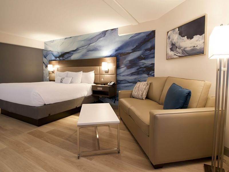 Hotel guestroom with king bed, a sofa and coffee table