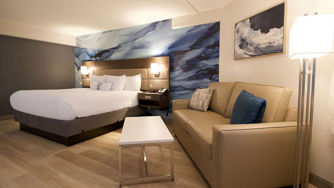 Hotel guestroom with king bed, a sofa and coffee table