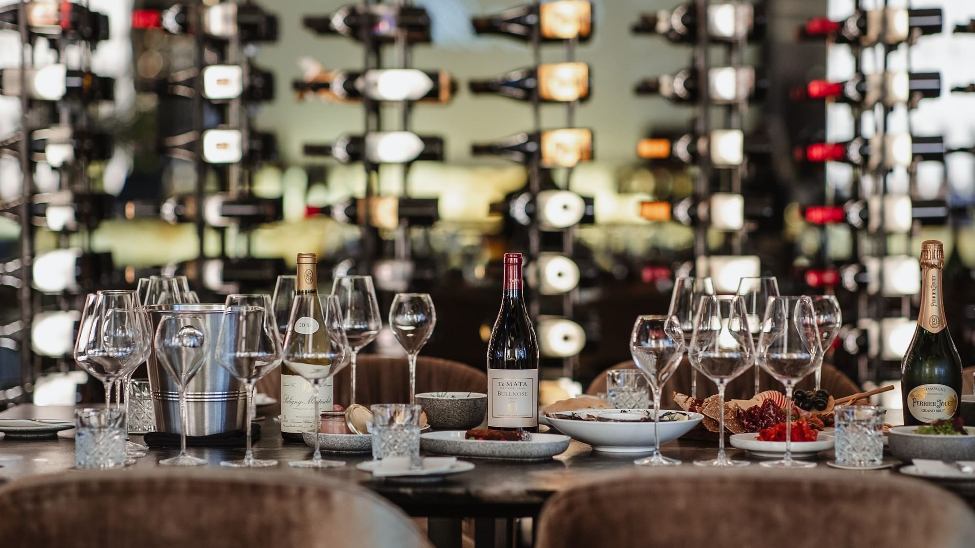 Table with wine glasses, bottles of wine and cheese platter in The Reserve Wine Bar
