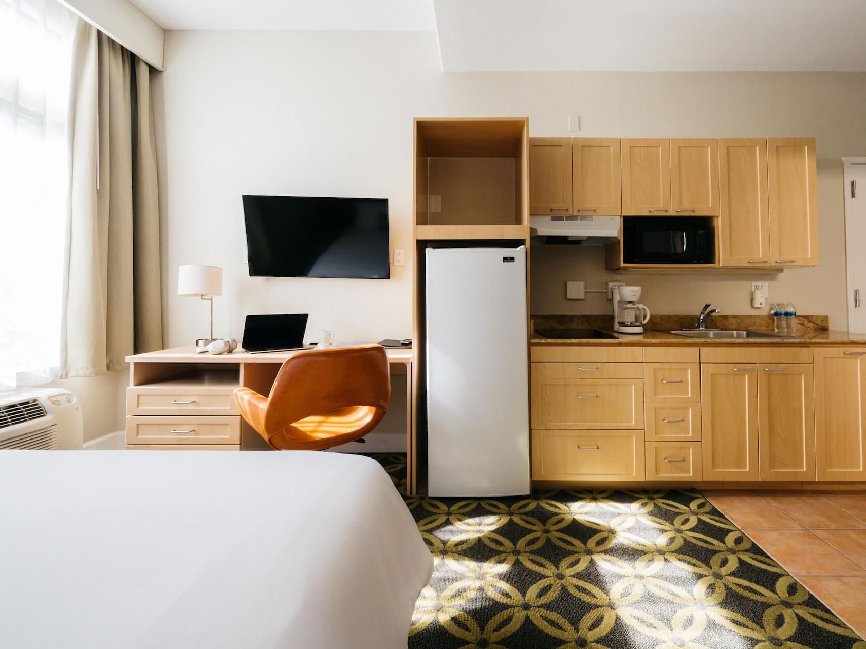 Kitchenette & work desk by the the king bed in a Room at Nesuto Hotels