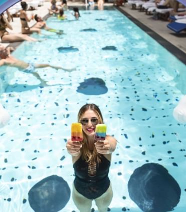 Girl holding 2 ice pops in Pool at Dream Downtown New York